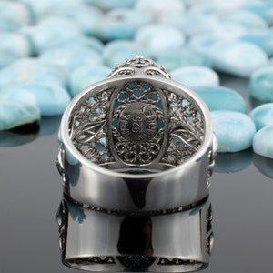 May include: Silver ring featuring a turquoise stone set within a filigree design. The ring is hallmarked "925 TURKEY" on the inside.