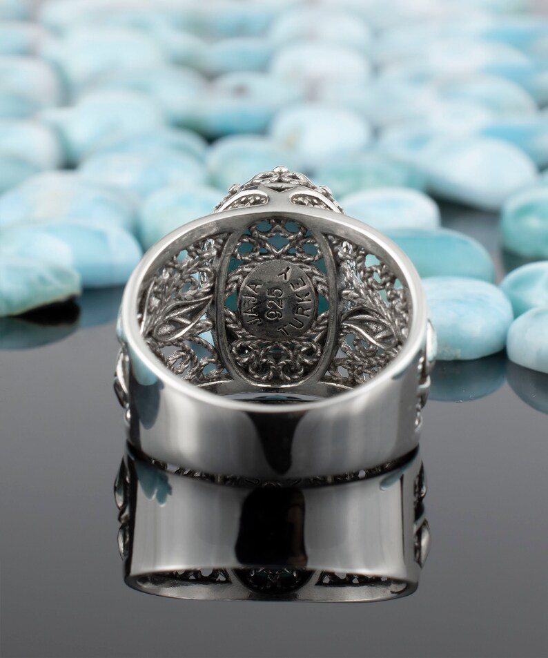 May include: Silver ring featuring a turquoise stone set within a filigree design. The ring is hallmarked "925 TURKEY" on the inside.