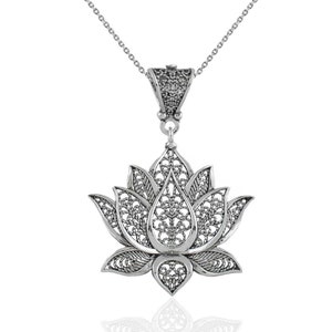 May include: Silver filigree lotus flower pendant necklace. The pendant is detailed with intricate cutouts and hangs from a delicate silver chain.