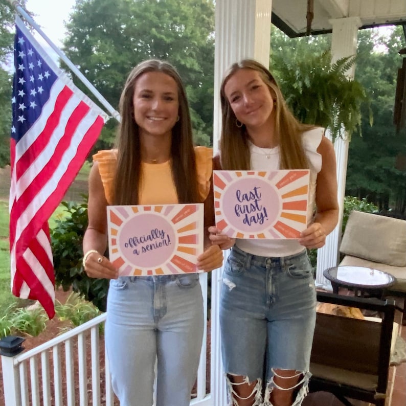 Teen girls holding Last First day signs for the first day of senior year