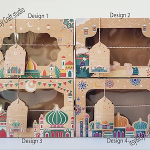 May include: Four brown cardboard gift boxes with clear windows and decorative tags. Each box features a different design with colorful illustrations of mosques, lanterns, and crescent moons. The text "Design 1", "Design 2", "Design 3", and "Design 4" is visible.