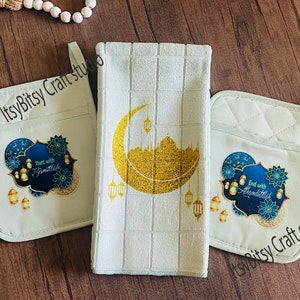 May include: Set of three white kitchen towels with a blue and gold design. The towels feature a crescent moon, a mosque, and lanterns. The text "Start with Bismillah" and "End with Alhamdulillah" is printed on two of the towels.