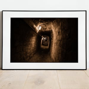 May include: A long, dark, brick tunnel with a series of lights leading to the end.