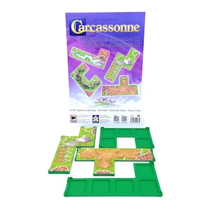 Könnte beinhalten: Ein Brettspiel-Set mit einer lila und weißen Box mit dem Titel "Carcassonne" und dem Text "Die Wunder der Menschheit III". Das Set enthält grüne Spielbrettteile und Landschaftskacheln mit Illustrationen.