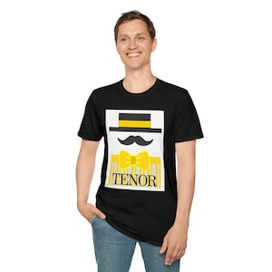 May include: Black t-shirt featuring a graphic of a hat, mustache, and bow tie in yellow and black, with the word "TENOR" in yellow. The design is on a white background.