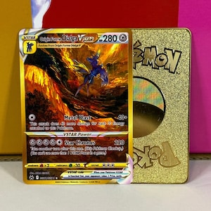 May include: A gold Pokémon trading card featuring Origin Forme Dialga VSTAR with a background of a fiery orange and yellow landscape. The card has a VSTAR power called Star Chronos and an attack called Metal Blast. The card is from the Sword & Shield - Brilliant Stars set.