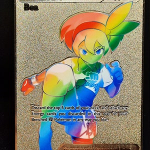 May include: A gold foil Pokemon trading card featuring Bea, a trainer from the Pokemon Trading Card Game. The card has a rainbow effect and the text "Discard the top 5 cards of your deck, and attach any Energy cards you discarded in this way to your Benched Pokemon in any way you like."