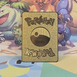 May include: Gold Pokemon card with a black Pokeball logo and the text "Pokemon" and "Pokemon" in a gold, stylized font.