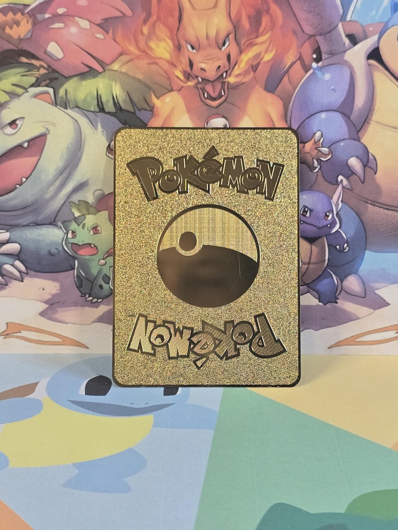 May include: Gold Pokemon card with a black Pokeball logo and the text "Pokemon" and "Pokemon" in a gold, stylized font.