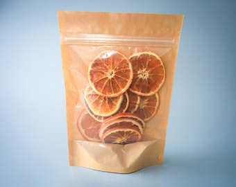 May include: A clear plastic bag with a brown paper exterior contains dried orange slices. The bag has a zipper closure.