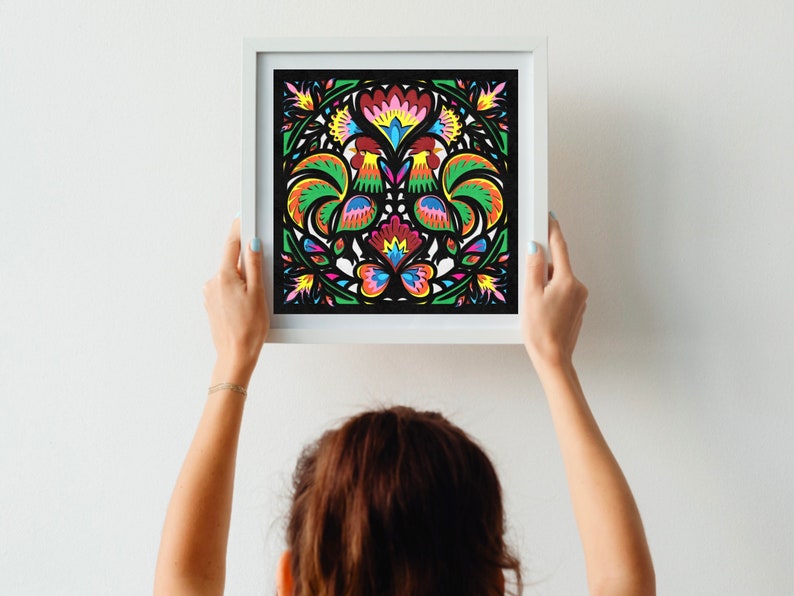 May include: A framed artwork featuring a colorful rooster and floral design. The artwork is in a white frame and has a black background.