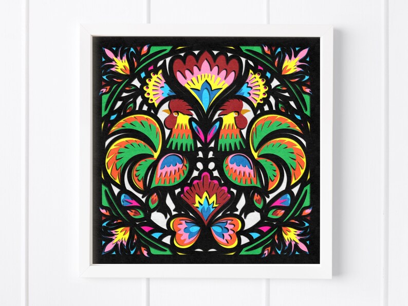 May include: A colorful paper cut art piece featuring two roosters with intricate designs and a butterfly in the center. The roosters are facing each other and have green, red, yellow, and blue feathers. The butterfly has pink, blue, and yellow wings.