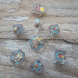May include: Set of eight blue and clear dice with a ramen noodle and egg design. The dice are numbered 1 through 6 and have a unique design on each side.