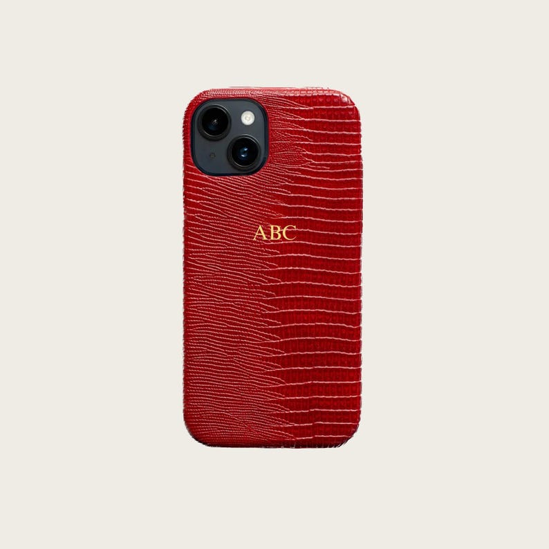 a red phone case with a textured pattern and a gold "ABC" logo on the back.