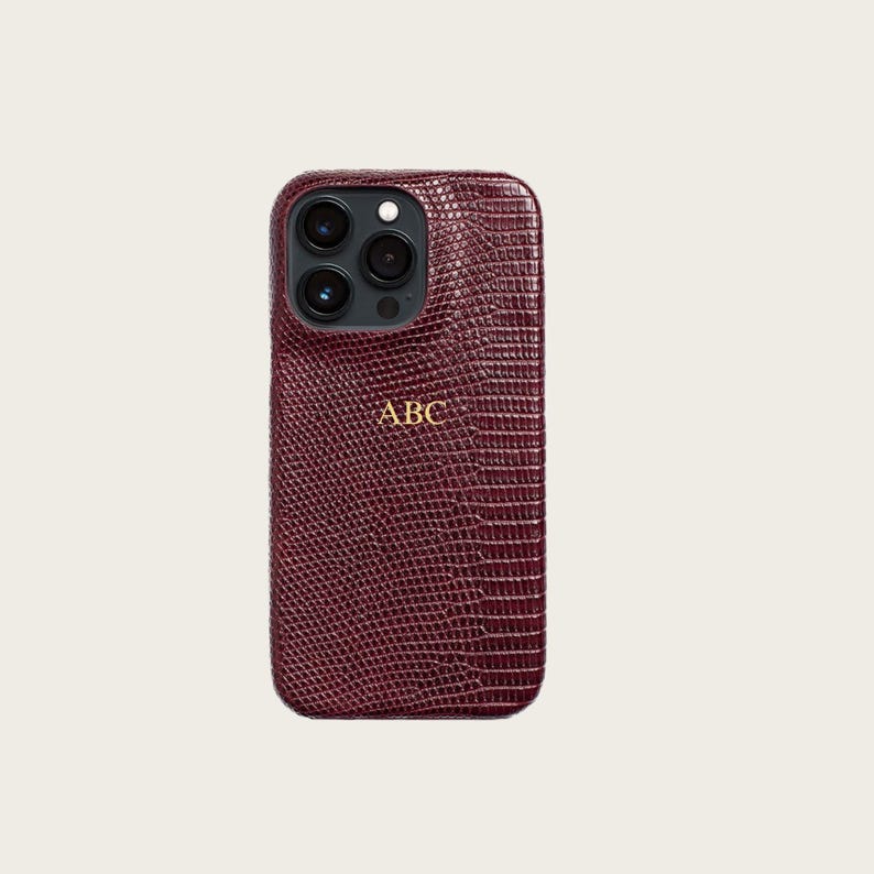 a burgundy-colored phone case with a textured pattern and a personalized logo on the back.