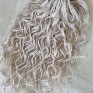 May include: A white ceramic mug with a black handle and the text "But First, Coffee" in a bold, black font. The mug is set against a blurred background, highlighting its clean design.