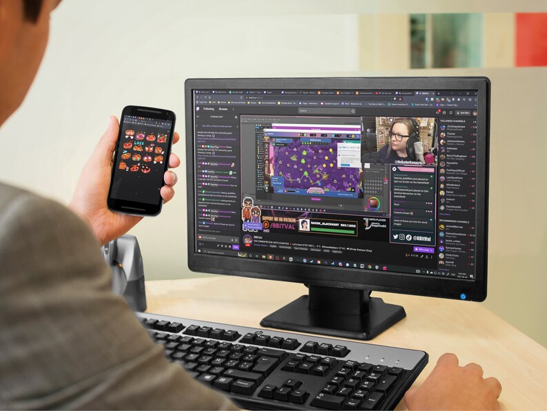 A man is looking at pumpkin emotes on his android phone while watching Twitch.