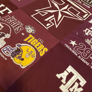 May include: A maroon fabric quilt with various patches featuring college logos and text. The patches include the logos for Texas A&M Aggies, LSU Tigers, Alabama Crimson Tide, and a star with the text "Tuscaloosa, Alabama". The quilt also features the text "Old  House" and "November 24, 2018".