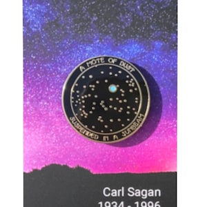 Pin esmaltado "Una mota de polvo" de Carl Sagan sobre tarjeta decorativa