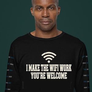May include: A black long-sleeve shirt featuring a white graphic of a Wi-Fi signal icon above the text "I MAKE THE WIFI WORK YOU'RE WELCOME" in a distressed font. The sleeves have a repeating pattern of small blue and grey rectangular accents.