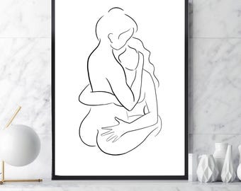 May include: A framed black and white line art print depicting two figures embracing. The minimalist artwork features a continuous line drawing of two people in an intimate embrace, with one figure's arm wrapped around the other. The print is displayed on a white marble surface.