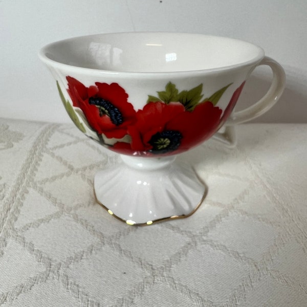 A very pretty and unusual, pedestal footed, vintage porcelain teacup, with a lovely poppy design