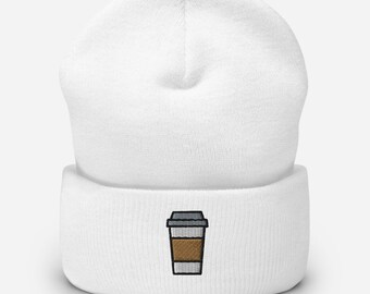 May include: White beanie with an embroidered coffee cup design. The coffee cup is brown with a black outline and a gray lid. The beanie is made of a soft, knitted material.