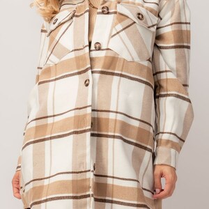 Puede incluir: Chaqueta camisa a cuadros beige y blanca con detalles marrones. La camisa de manga larga tiene dos bolsillos en el pecho y botones marrones. La chaqueta es de color neutro y es adecuada para oto&ntilde;o o invierno.