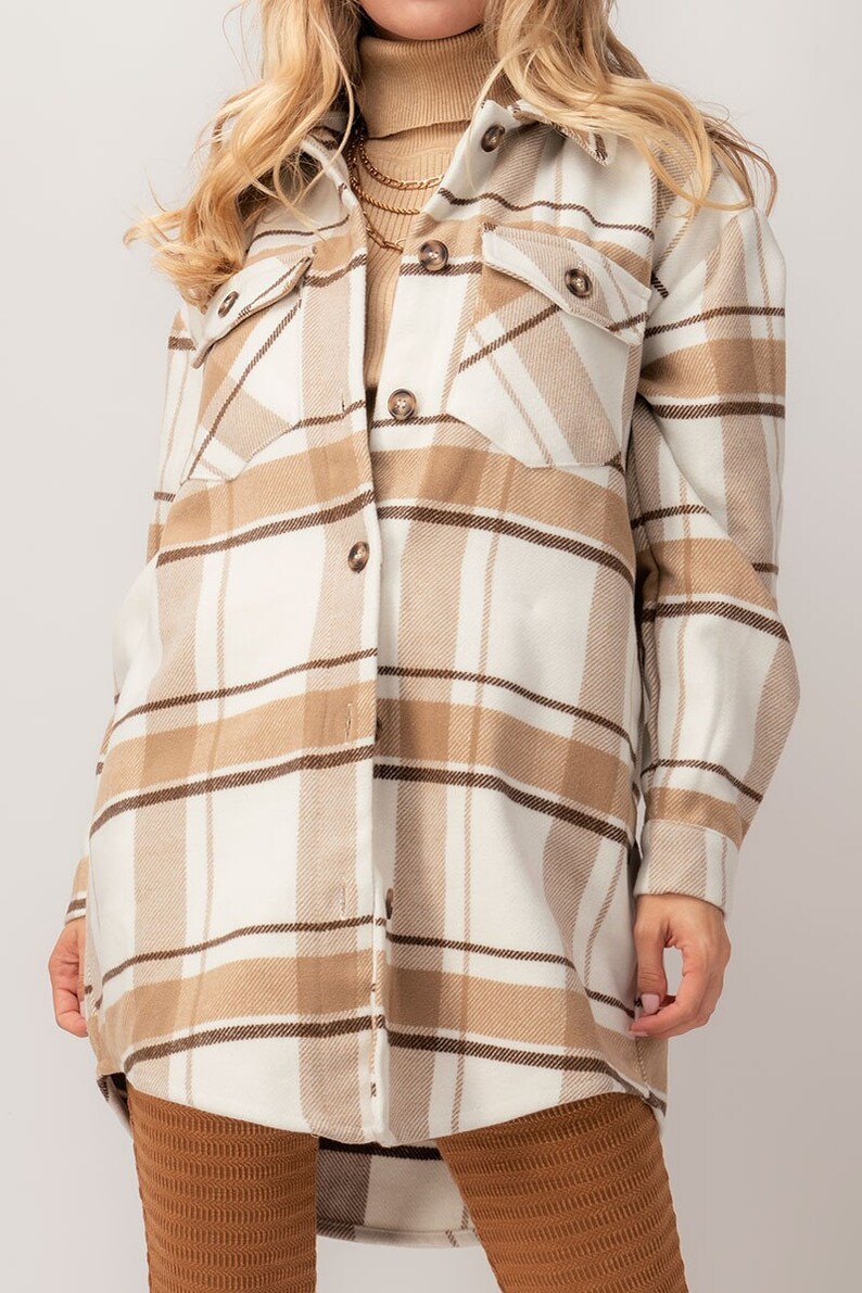 Puede incluir: Chaqueta camisa a cuadros beige y blanca con detalles marrones. La camisa de manga larga tiene dos bolsillos en el pecho y botones marrones. La chaqueta es de color neutro y es adecuada para oto&ntilde;o o invierno.