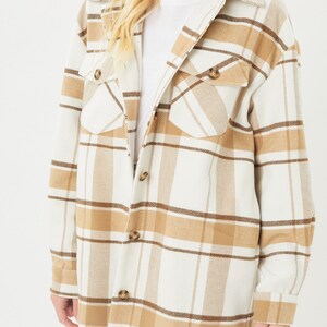 Puede incluir: Chaqueta camisa a cuadros color crema con detalles en marr&oacute;n y beige. La chaqueta de manga larga presenta un cuello, cierres de botones y dos bolsillos delanteros. La chaqueta camisa es una opci&oacute;n de abrigo informal.