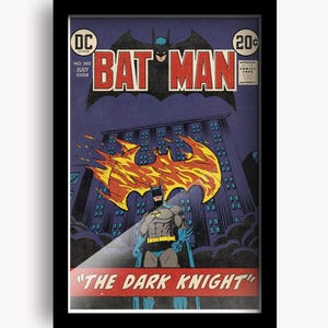 May include: A framed vintage comic book cover featuring Batman. The cover displays the title "BATMAN" in bold red letters, with a bat silhouette above. The image includes the text "THE DARK KNIGHT" at the bottom, with a cityscape and Batman in the foreground.