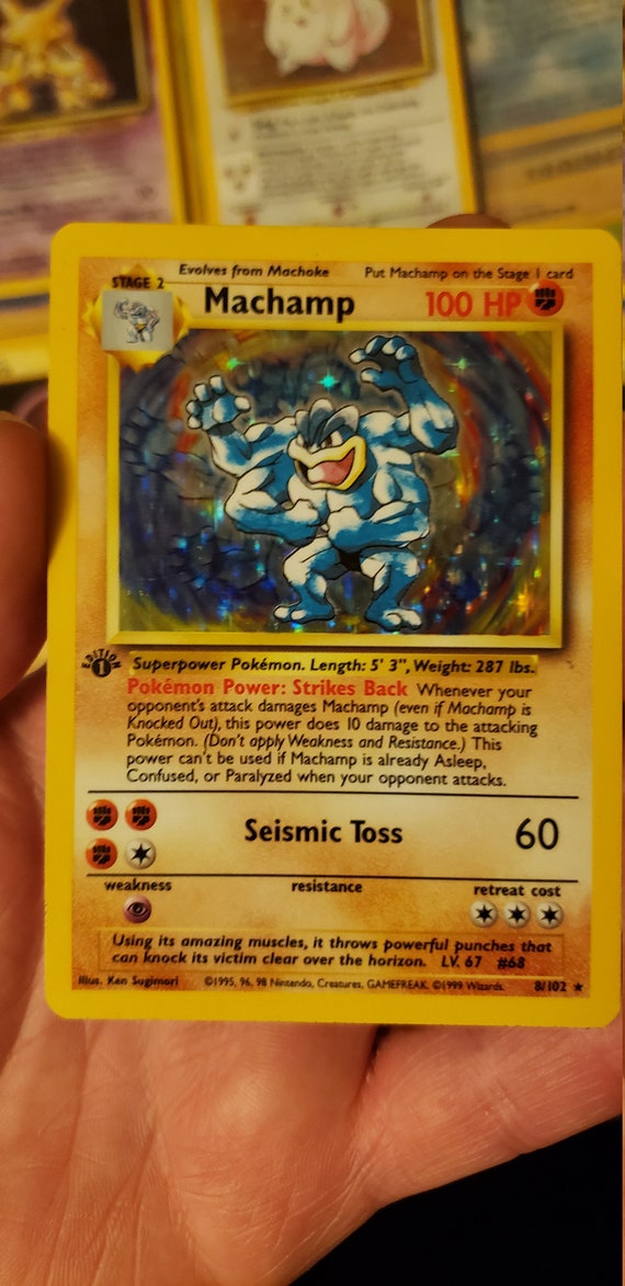 1995 machamp pokemon card Machamp Cosmo Holo 1st Edition 8/102Illus. Ken Sugimori Featuring my original copy of the ultimate fighting champ,  There are so many variants of this card, but this cosmo holo variant Strikes Back Whenever your opponents attack damages Machamp (even if Machamp is Knocked Out) Light Machamp (25/105) - Neo