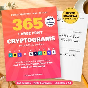 May include: A bright red book cover titled 365 Large Print Cryptograms for Adults & Seniors with yellow text, a white starburst graphic, and colourful letter tiles. Beside it lies a white printed page with puzzle lines and a yellow circular badge.