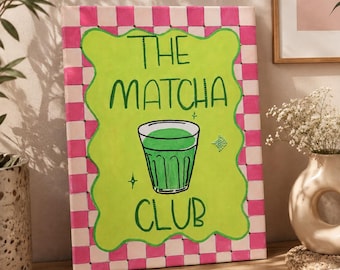 May include: A rectangular canvas painting featuring a pink and white checkered border surrounding a lime green wavy-edged center. The text THE MATCHA CLUB is written in dark green, centered above and below a drawing of a glass of green matcha.