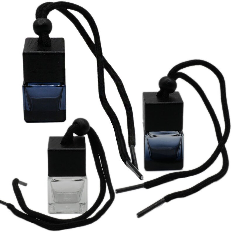 May include: Three black and clear glass car air fresheners with black wooden tops and black string hangers.