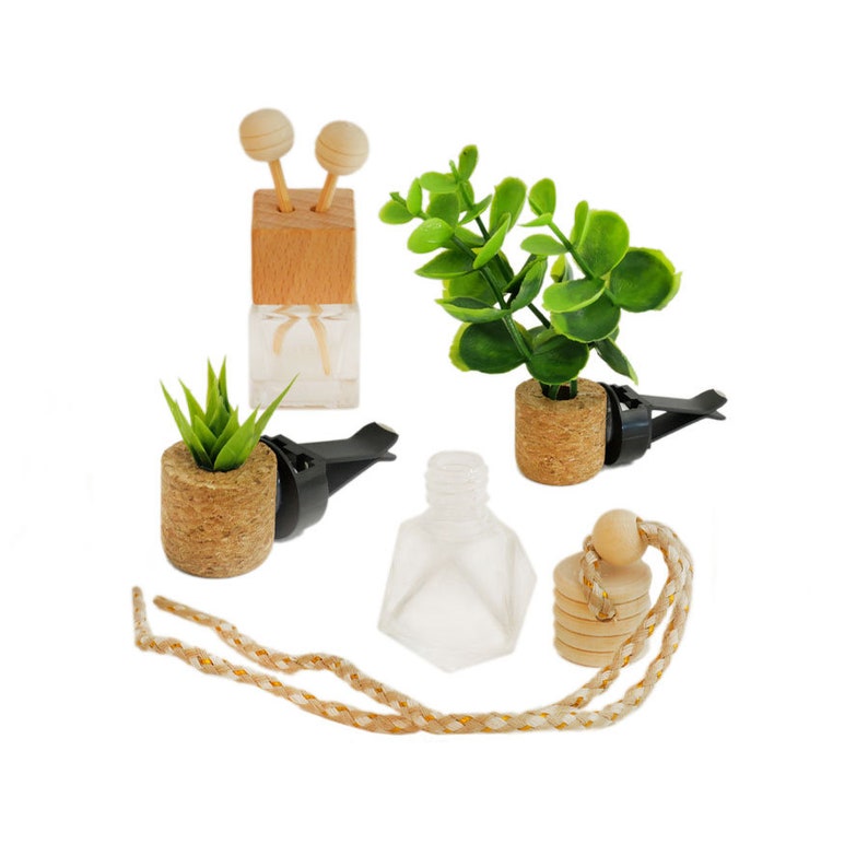 May include: Set of four car air fresheners with different designs.  Two are glass bottles with cork tops, one is a glass bottle with a wooden top and two wooden sticks, and one is a glass bottle with a cork top and a wooden bead hanging from a string.