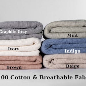 Puede incluir: Cinco muestras de tela de algod&oacute;n dobladas en diferentes colores: gris grafito, marfil, marr&oacute;n, menta, &iacute;ndigo y beige. El texto "100% algod&oacute;n y tejido transpirable" est&aacute; debajo de las muestras.
