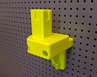 Può includere: Un supporto da parete in plastica giallo brillante con due fori. Il supporto è progettato per contenere un piccolo oggetto, come uno strumento o un telefono.