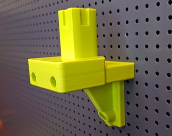 Può includere: Un supporto da parete in plastica giallo brillante con due fori sul lato e una piccola apertura rettangolare sul fondo.
