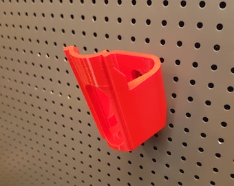 May include: A red plastic wall mount hook for hanging items on a pegboard.