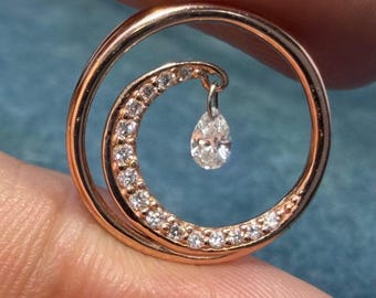 Colgante circular de oro de 14k con diseño de ola oceánica y diamante colgante en forma de lágrima.