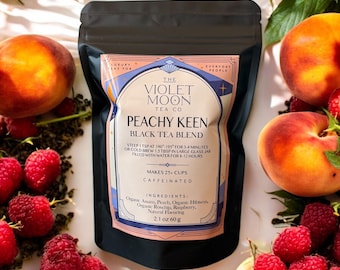 May include: A black tea blend bag from The Violet Moon Tea Co. with the text "Peachy Keen Black Tea Blend". The bag is surrounded by fresh peaches and raspberries. The ingredients include organic Assam, peach, hibiscus, rosehips, and raspberry.