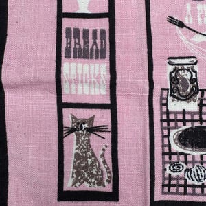 Pu&ograve; includere: Tessuto rosa con strisce verticali nere e illustrazioni incorniciate. Il tessuto presenta un gatto, il testo "Bread Sticks" e disegni a tema cucina. Il design generale ha un'estetica vintage.