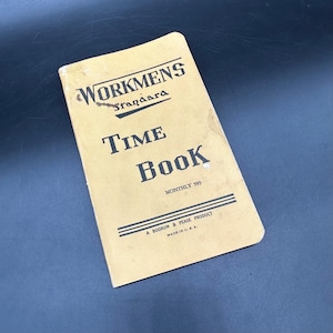 以下が含まれることがあります： ベージュ色の表紙のヴィンテージ「Workmens Standard Time Book」。表紙には「Workmens Standard Time Book」と「Monthly 593」と書かれた黒い文字があります。本の底には「A Boorum & Pease Product Made in U.S.A.」と書かれています。