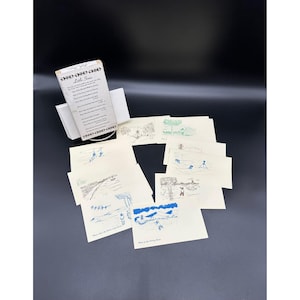 May include: A set of 10 illustrated cards with black and white drawings of people and animals. The cards are printed on white paper and have blue text. The text on the cards reads "Little Songs".