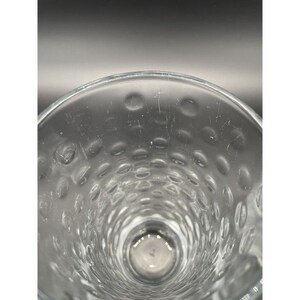 May include: Close-up of the inside of a clear glass with a textured, dimpled surface.