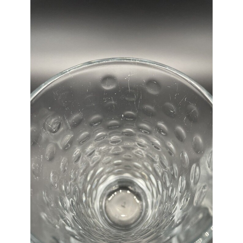 May include: Close-up of the inside of a clear glass with a textured, dimpled surface.