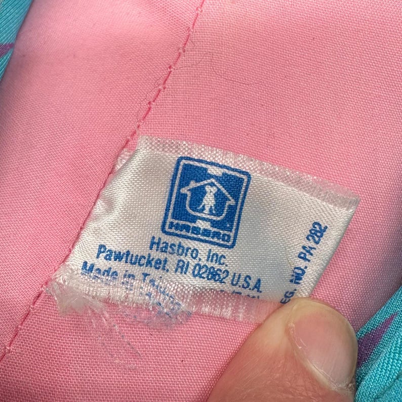 Peut inclure: Une &eacute;tiquette blanche avec du texte bleu et un logo bleu d'une maison avec un chien &agrave; l'int&eacute;rieur. L'&eacute;tiquette indique "Hasbro, Inc. Pawtucket, RI 02862 U.S.A. EG. NO. PA 282".