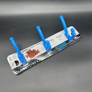 May include: A blue plastic multi-hook rack from Closet Trends. The rack has three hooks and is labeled "The Multi Hook". The packaging also states "Sturdy Colorful Plastic". The hooks are a vibrant blue color.