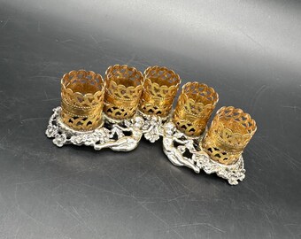Soporte para pintalabios vintage en tonos dorados y plateados con querubines, 5 ranuras, tocador estilo Regencia ornamentado.